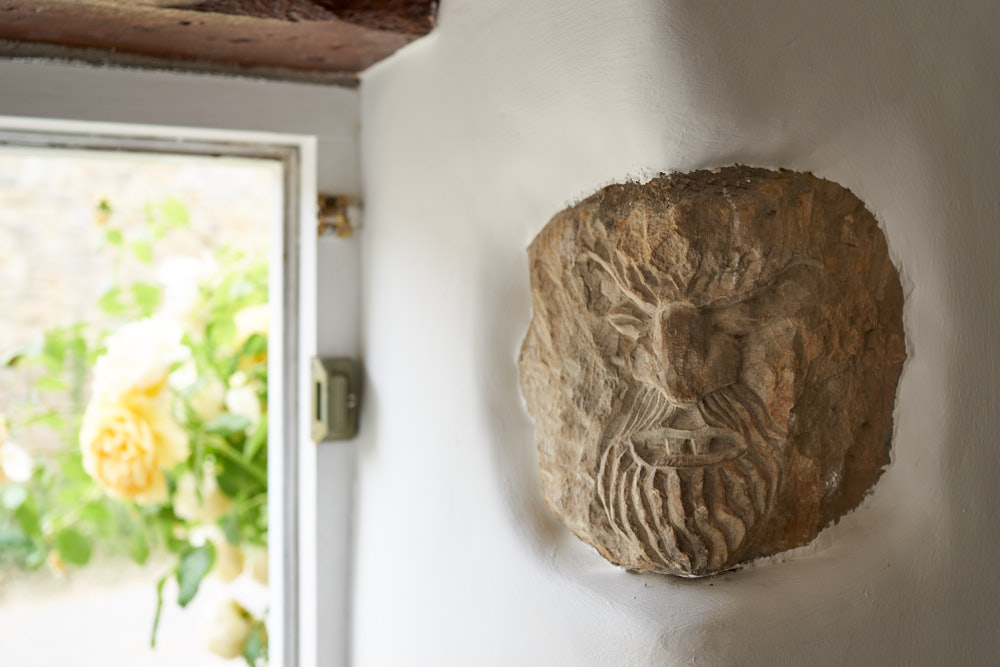 Traditional stone carving detail at the cottage entrance